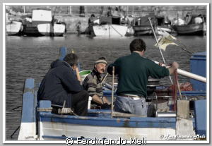 A fisherman tells his friends about his fishing adventure... by Ferdinando Meli 
